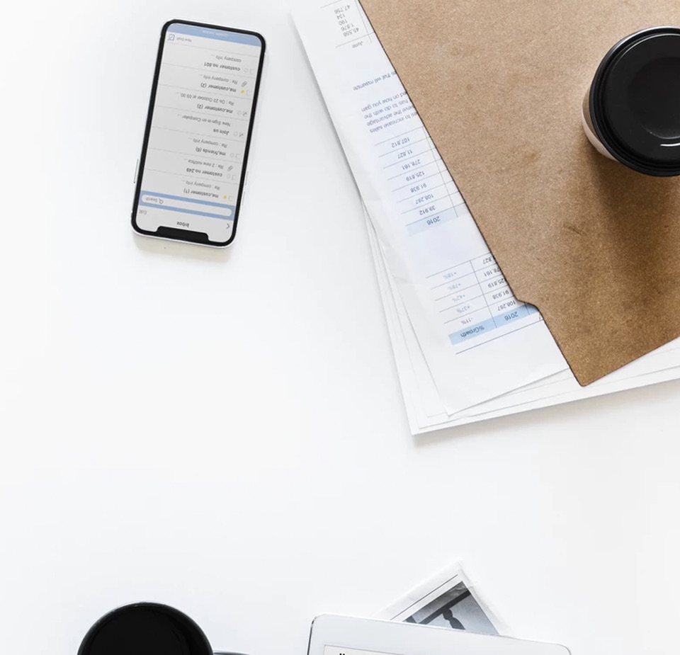 top view of table with phone, work file and coffeee