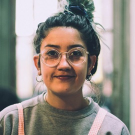 female with glasses wearing a sweatshirt